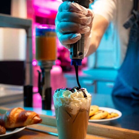 Portion Pump MAX dispenses chocolate sauce on a Frappuccino